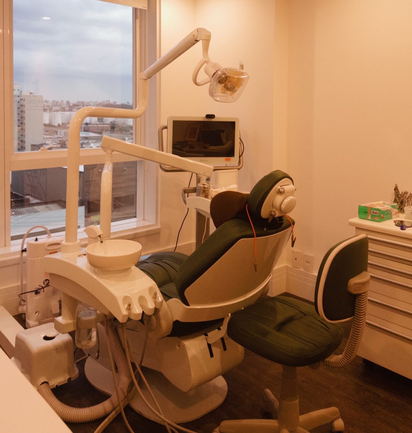 Consultório com cadeira odontológica e janela com vista da cidade